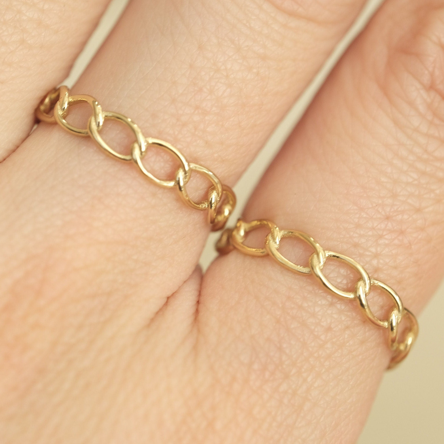 a close up of a person's hand wearing a gold ring