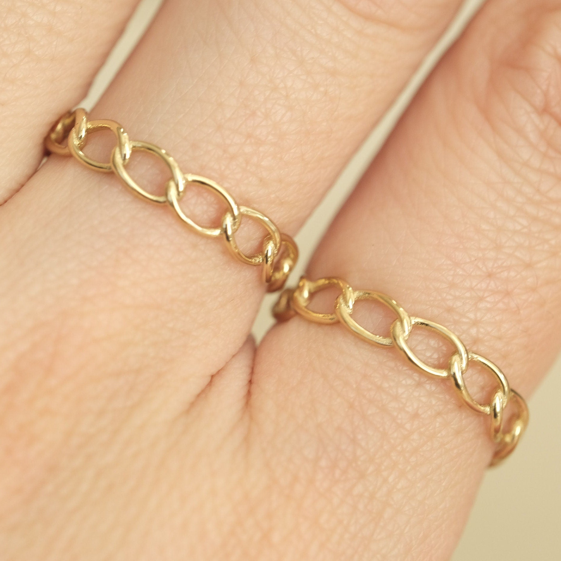 a close up of a person's hand wearing a gold ring