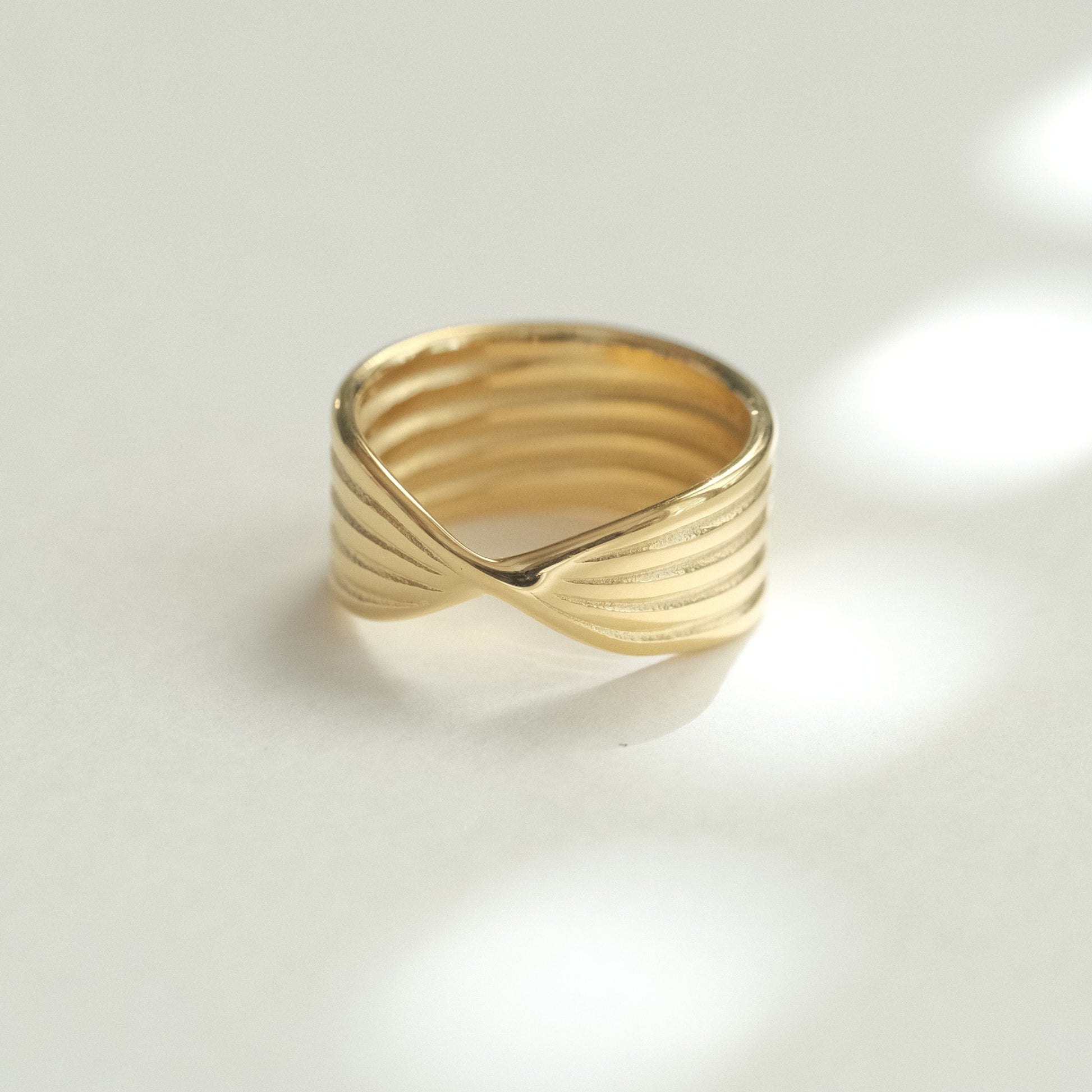 a gold ring sitting on top of a white surface