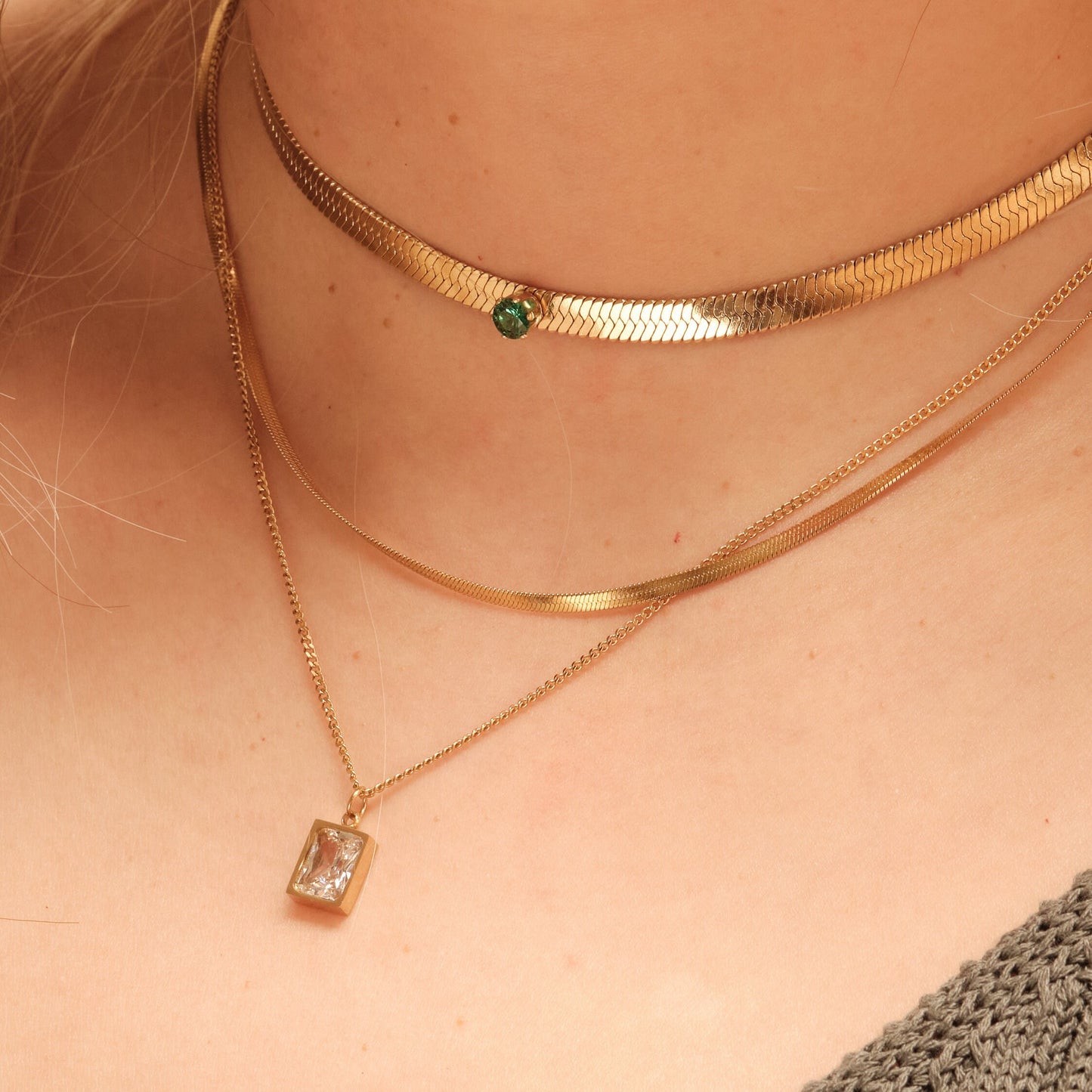 a close up of a woman wearing a gold necklace